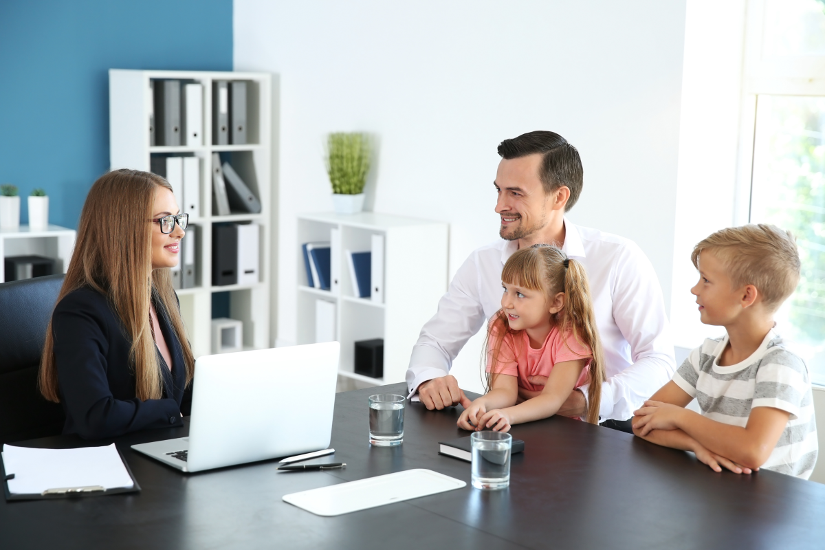 A teacher meets with a father and his son and daughter.