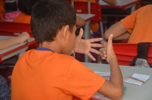 A student counts on his fingers while working through a math problem.